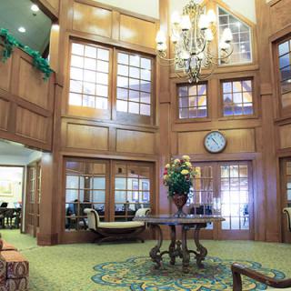 A spacious lobby featuring elegant wood paneling, a grand chandelier, and comfortable seating areas.