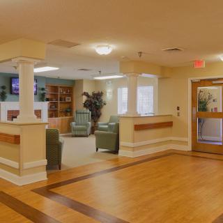 A cozy and welcoming nursing home lobby with comfortable seating.