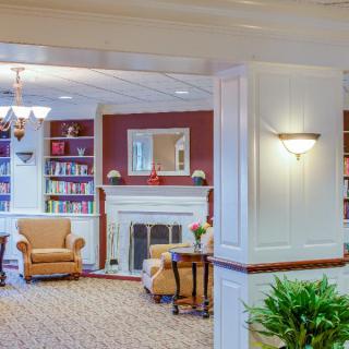 A cozy living room with a fireplace, bookshelves, and comfortable armchairs.