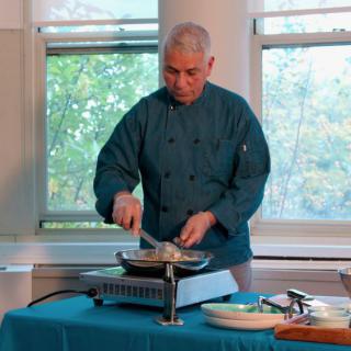 A chef preparing a dish on an indoor stove.