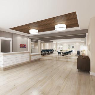 A modern and spacious lobby area featuring a reception desk and adjacent conference room, highlighted by stylish lighting and wooden ceiling accents.