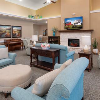 A cozy living room with blue sofas, a fireplace, and a television.