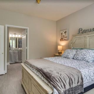A cozy bedroom with a neatly made bed, bedside lamp, and elegant decor.