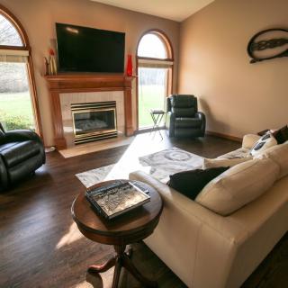 A cozy living room with modern furniture, a fireplace, and a large TV.