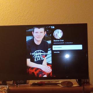 A profile displayed on a television screen showing a young man.