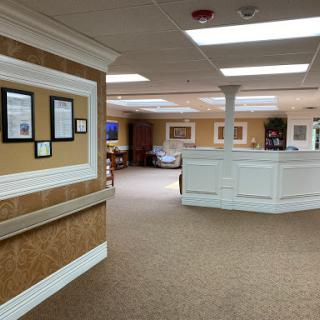 A spacious and well-lit office reception area, featuring framed documents on the walls and a welcoming ambiance.