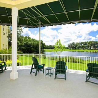 A peaceful patio overlooking a serene lake surrounded by greenery.