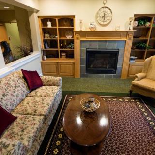 Cozy living room with a floral couch, fireplace, and bookshelves.