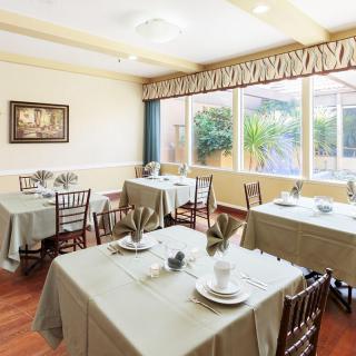 A bright dining area with elegantly set tables and large windows.