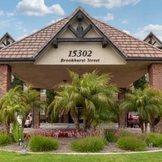 Entrance of a building with palm trees and an address sign.