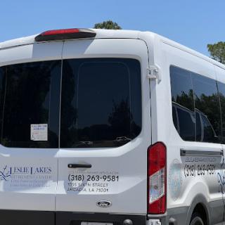 A white van parked, showcasing its rear and windows.
