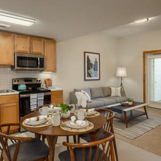 A cozy open-concept apartment with a fully equipped kitchen, dining area, and comfortable living room.
