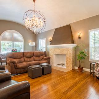 A cozy living room with a chandelier, comfortable seating, and a fireplace.