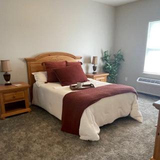 A cozy bedroom with a neatly made bed and warm decor.