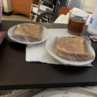 A simple meal of sandwiches and a drink served in a hospital setting.