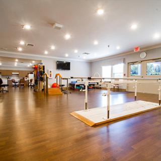 A well-lit rehabilitation therapy room equipped for physical therapy exercises.