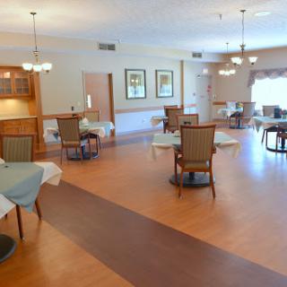 A spacious and well-lit dining area featuring tables and chairs designed for communal gatherings.