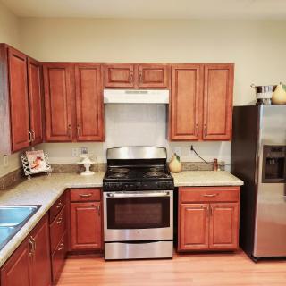 A modern kitchen with wooden cabinets and stainless steel appliances.