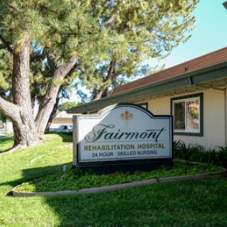 The entrance sign of Fairmont Senior Living, set against a backdrop of greenery.