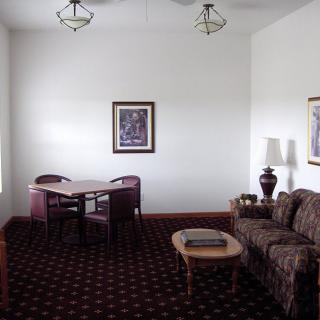 A cozy living room with a sofa, coffee table, and dining area.