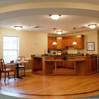 An open kitchen with wooden cabinetry and a small dining area.