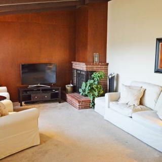 A cozy living room with sofas, a television, and a fireplace.