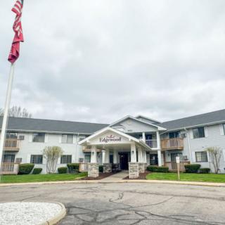 The exterior view of a hotel with an entrance and flagpole on a cloudy day.