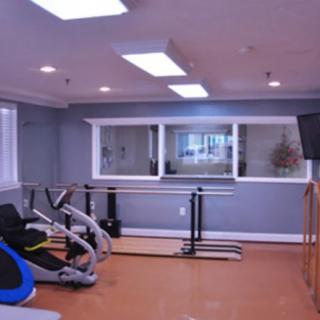 A small gym room with exercise equipment and mirrors.