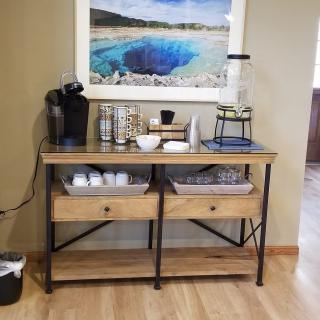 A well-organized coffee station with a wooden counter and various coffee essentials.