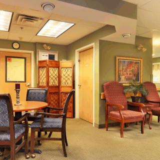 A cozy waiting room with comfortable chairs and a table, complemented by warm decor.