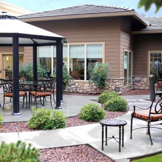 A well-maintained patio area featuring a gazebo, outdoor furniture, and surrounding landscaping.