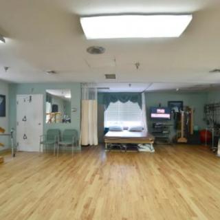 A spacious rehabilitation room equipped for physical therapy.