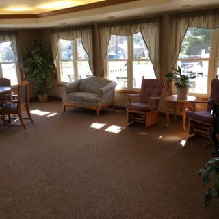 A cozy living room space filled with natural light, featuring comfortable seating and a welcoming atmosphere.