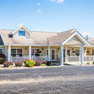 A charming single-story house with a front porch under a clear blue sky.