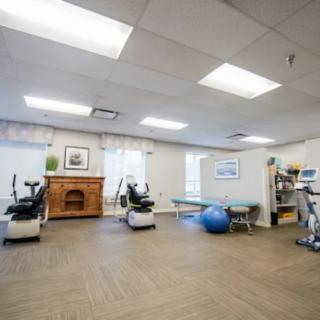 A well-lit gym space with exercise equipment, suitable for fitness and rehabilitation activities.