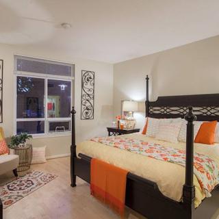 A cozy and well-decorated bedroom with a large bed, nightstand, and elegant decor.