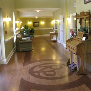A well-lit hallway with wooden floors and decorative furniture.