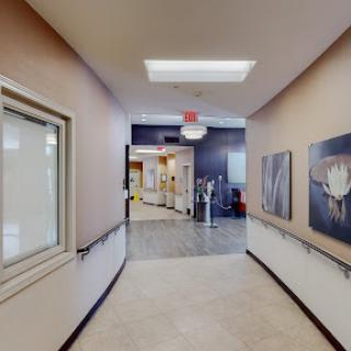 A well-lit hallway in a medical facility, featuring decorative art on the walls.