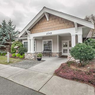 A charming suburban house with a well-kept front porch and landscaping.