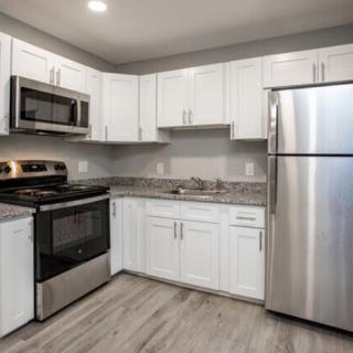 Modern kitchen with white cabinets and stainless steel appliances.