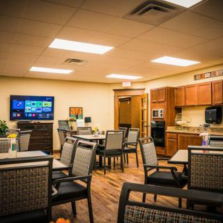 A cozy dining area with a modern kitchen and television setup.