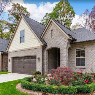 A modern brick house with a landscaped garden and attached garage.
