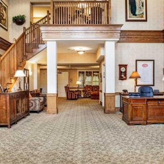 A spacious lobby area with a reception desk and a staircase leading to an upper level.