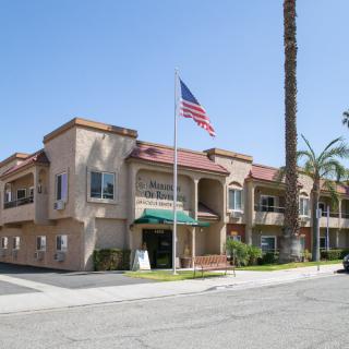 A sunny day at a residential or commercial building with an American flag and palm trees.