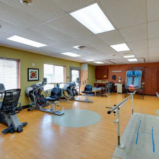A well-equipped gym designed for rehabilitation and physical therapy, featuring various exercise machines and an inviting atmosphere.