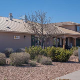 A residential house with desert landscaping under a clear blue sky.