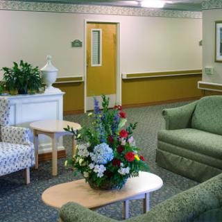 A cozy waiting area featuring comfortable furniture and a floral arrangement.