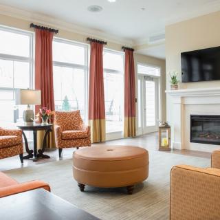 A modern living room featuring a cozy seating area with a fireplace and large windows.