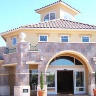 A Mediterranean-style building with an arched entrance and stone facade.