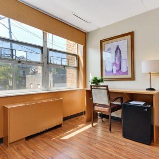 A bright office space with a desk, chair, and artwork on the wall.